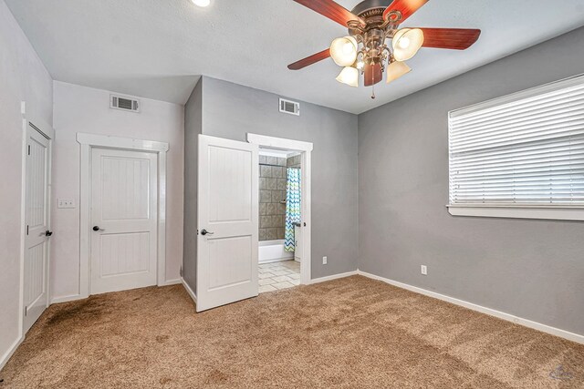 10500 E County Rd 90, Midland, TX 79706 - unfurnished bedroom featuring carpet floors, baseboards, ensuite bath, and a ceiling fan