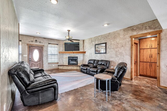 10500 E County Rd 90, Midland, TX 79706 - living room featuring a ceiling fan, a fireplace, a textured ceiling, concrete flooring, and baseboards