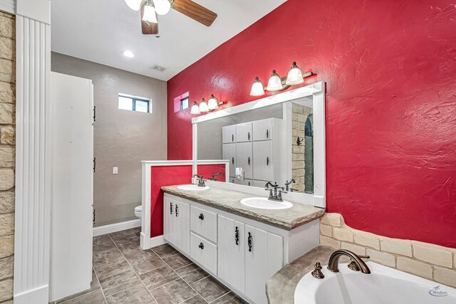 10500 E County Rd 90, Midland, TX 79706 - bathroom with ceiling fan, toilet, a bath, and double vanity