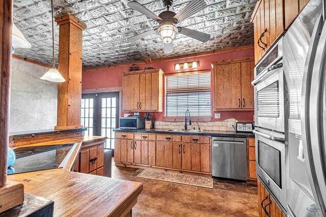10500 E County Rd 90, Midland, TX 79706 - kitchen with stainless steel appliances, a sink, an ornate ceiling, ceiling fan, and brown cabinets