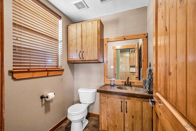 10500 E County Rd 90, Midland, TX 79706 - half bathroom featuring toilet, vanity, baseboards, and a textured wall