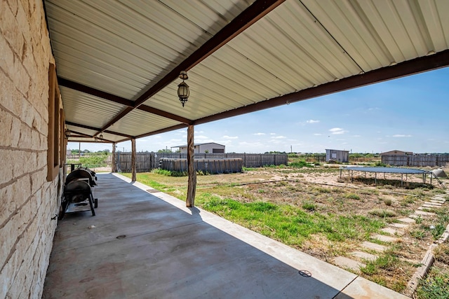 10500 E County Rd 90, Midland, TX 79706 - fenced backyard with a trampoline and a patio