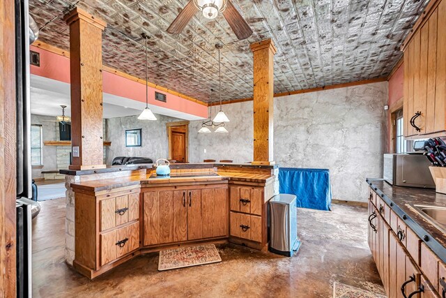10500 E County Rd 90, Midland, TX 79706 - kitchen featuring concrete floors, decorative light fixtures, ceiling fan, tile counters, and brown cabinets