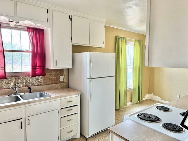 kitchen with white cabinets, white appliances, sink, and a wealth of natural light