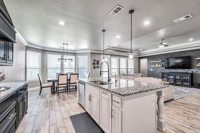 6003 Sunny Stone Dr, Midland, TX 79705 - kitchen with dishwasher, light wood-type flooring, crown molding, a textured ceiling, and light stone countertops