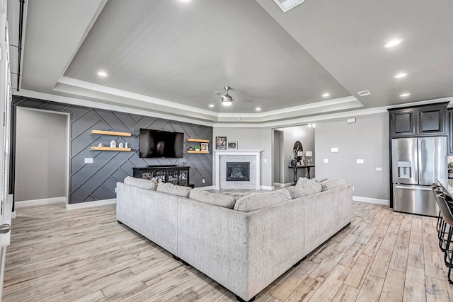6003 Sunny Stone Dr, Midland, TX 79705 - living area featuring a tray ceiling, a ceiling fan, light wood-style floors, a high end fireplace, and recessed lighting
