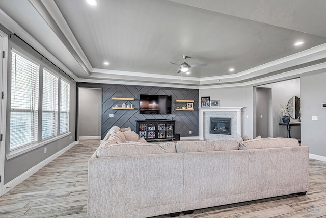6003 Sunny Stone Dr, Midland, TX 79705 - living room with a raised ceiling, light wood-type flooring, a glass covered fireplace, ceiling fan, and recessed lighting