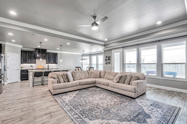 6003 Sunny Stone Dr, Midland, TX 79705 - living room with light wood finished floors, ceiling fan, crown molding, a tray ceiling, and recessed lighting
