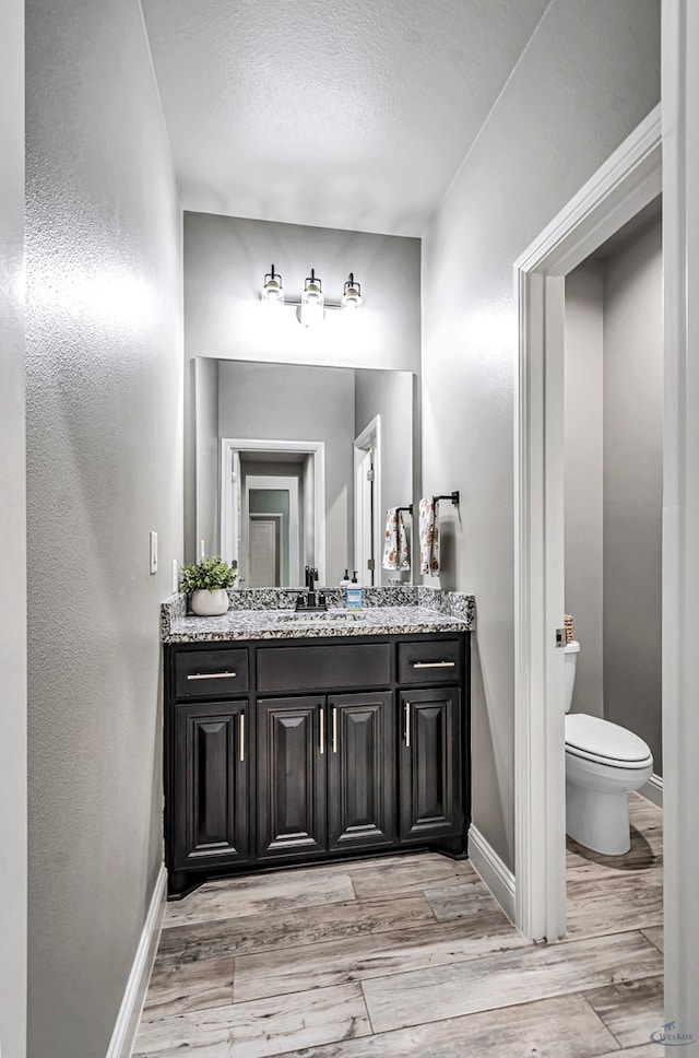 6003 Sunny Stone Dr, Midland, TX 79705 - bathroom featuring vanity, wood finished floors, and a textured ceiling