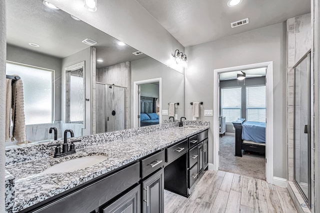 6003 Sunny Stone Dr, Midland, TX 79705 - ensuite bathroom featuring double vanity, wood finished floors, a stall shower, ceiling fan, and recessed lighting