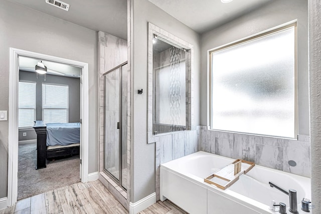 6003 Sunny Stone Dr, Midland, TX 79705 - bathroom featuring a bath, a shower stall, and wood finished floors