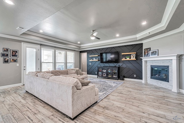 6003 Sunny Stone Dr, Midland, TX 79705 - living room with a raised ceiling, a glass covered fireplace, wood finished floors, ceiling fan, and ornamental molding