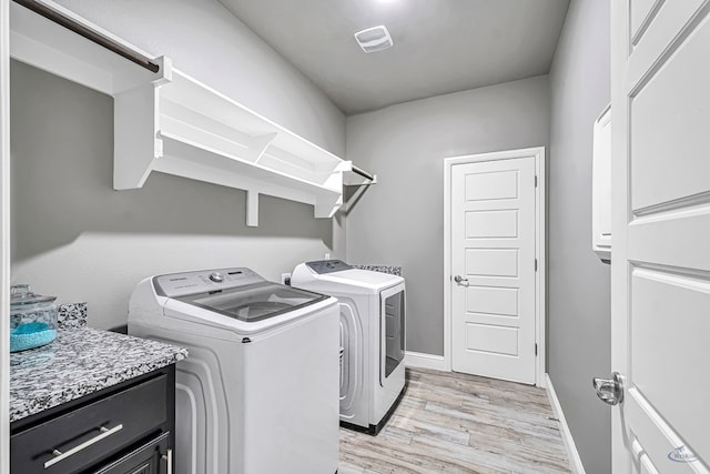 6003 Sunny Stone Dr, Midland, TX 79705 - laundry area with separate washer and dryer, light wood-style floors, and cabinet space
