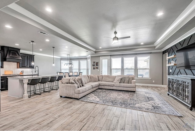 6003 Sunny Stone Dr, Midland, TX 79705 - living area with a tray ceiling, light wood-style flooring, a ceiling fan, ornamental molding, and recessed lighting