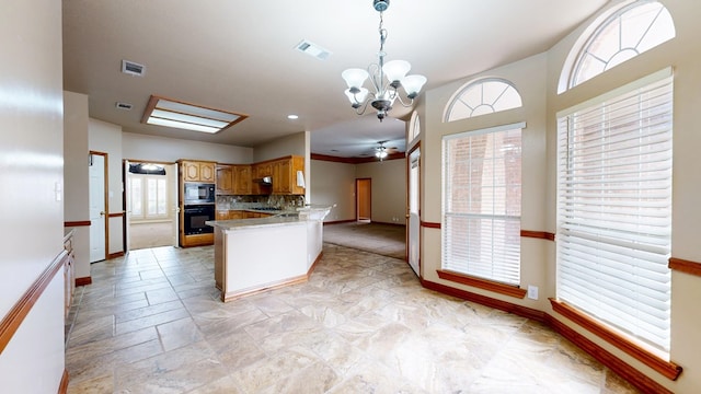 4513 Rosewood Dr, Midland, TX 79707 - kitchen featuring visible vents, built in microwave, baseboards, a peninsula, and black oven