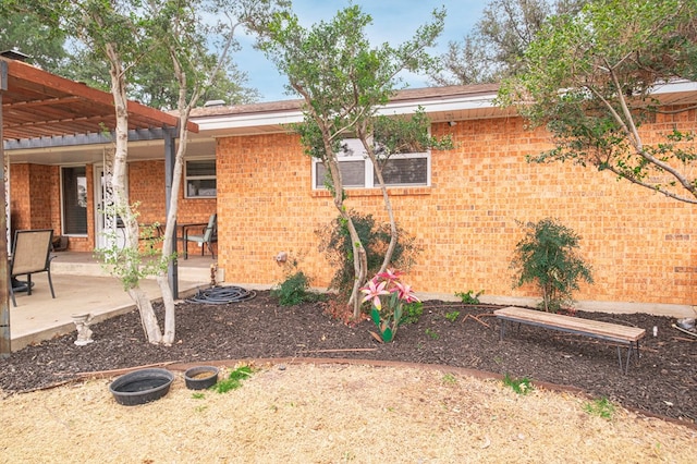 view of property exterior with a pergola and a patio area