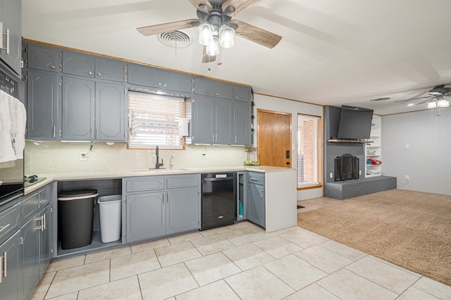 kitchen featuring black dishwasher, sink, gray cabinets, ceiling fan, and light carpet