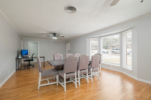 dining room with light wood-type flooring, ornamental molding, and ceiling fan