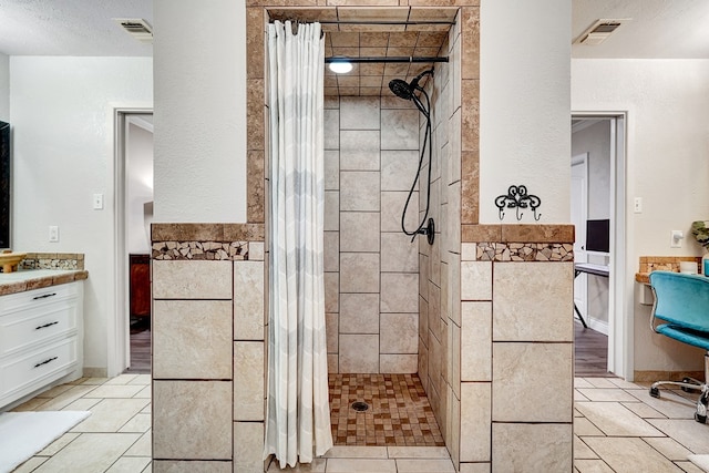 2406 Stutz Pl, Midland, TX 79705 - full bath featuring tiled shower, vanity, a wainscoted wall, and tile walls