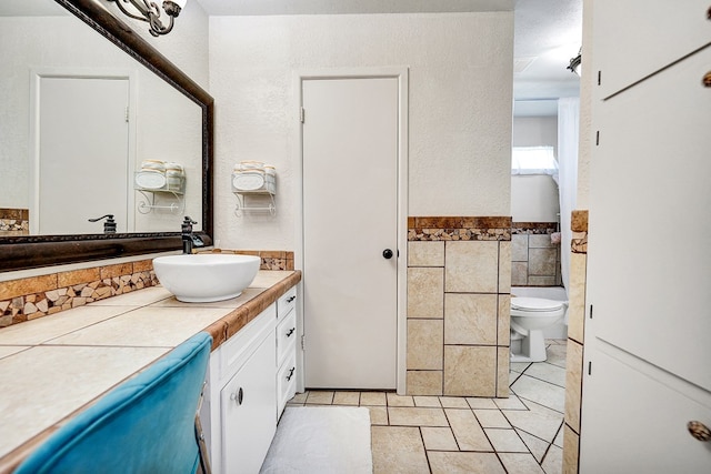 2406 Stutz Pl, Midland, TX 79705 - bathroom with vanity, tile walls, tile patterned floors, and a wainscoted wall