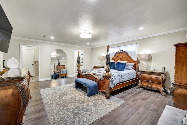 2406 Stutz Pl, Midland, TX 79705 - bedroom featuring arched walkways, wood finished floors, ornamental molding, a spacious closet, and recessed lighting