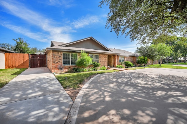 2406 Stutz Pl, Midland, TX 79705 - ranch-style house with brick siding, a gate, and concrete driveway