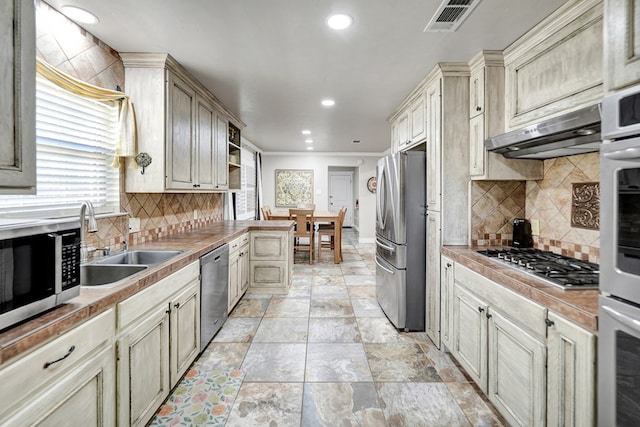 2406 Stutz Pl, Midland, TX 79705 - kitchen with stainless steel appliances, plenty of natural light, under cabinet range hood, recessed lighting, and tasteful backsplash