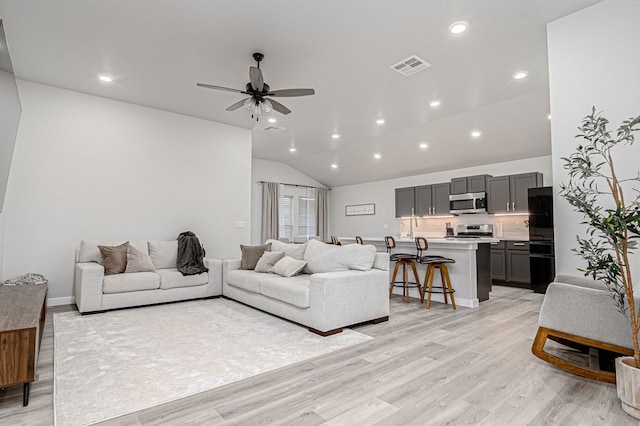 living room featuring vaulted ceiling, light wood-type flooring, ceiling fan, and recessed lighting