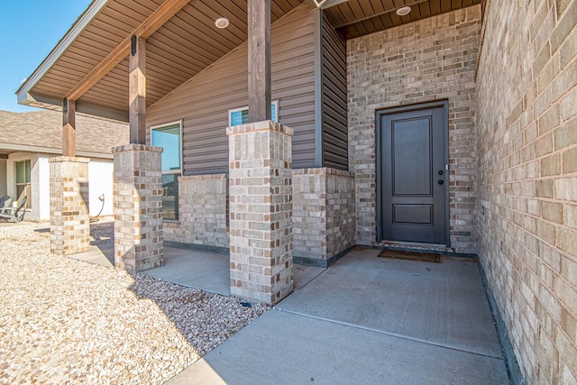 doorway to property featuring brick siding