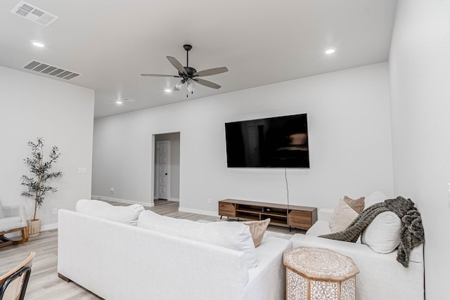 living room with light wood finished floors, a ceiling fan, recessed lighting, and baseboards