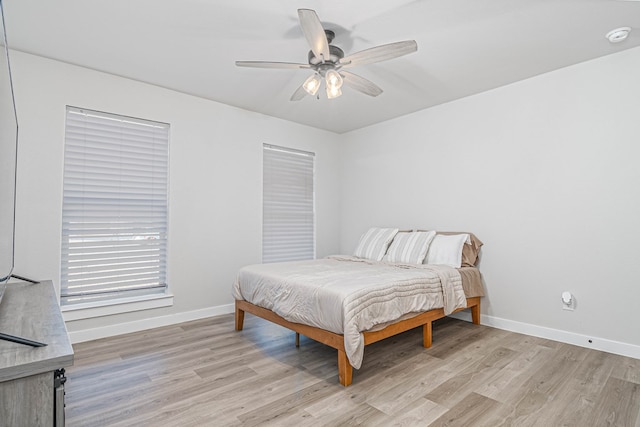 bedroom featuring light wood-type flooring, baseboards, and a ceiling fan