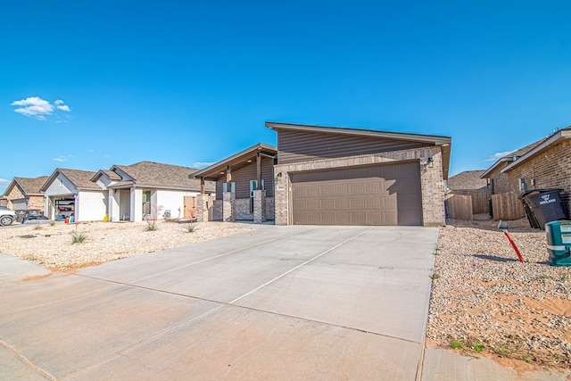 view of front of house with brick siding, driveway, a garage, and fence