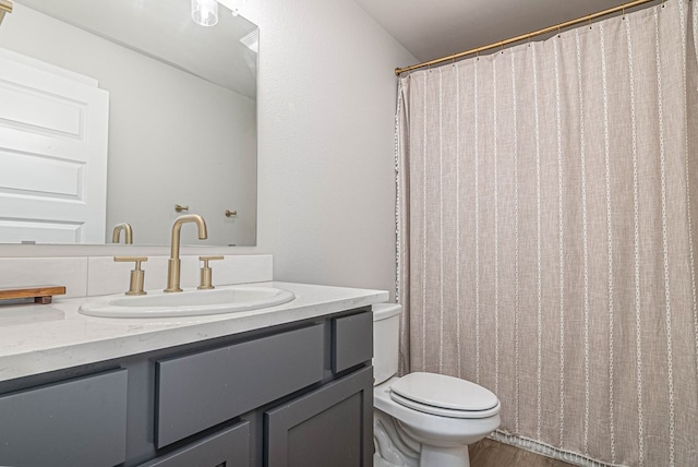 bathroom featuring toilet, vanity, a shower with curtain, and wood finished floors