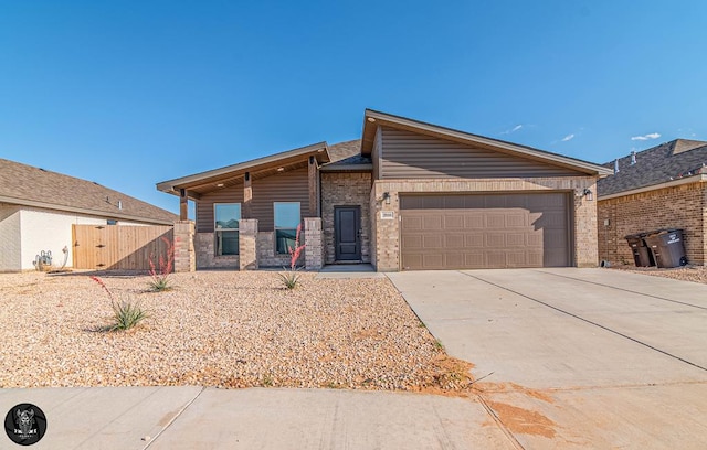 view of front of home with a garage, concrete driveway, a gate, and brick siding