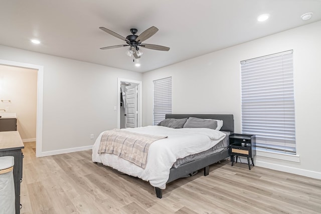 bedroom with light wood-style floors, baseboards, recessed lighting, a ceiling fan, and a walk in closet