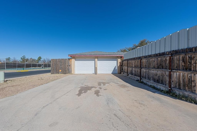 view of side of property featuring a detached garage, fence, and an outdoor structure