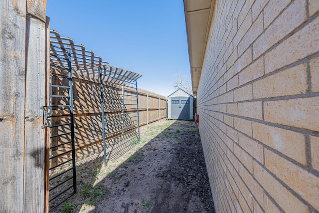 view of yard with a shed, an outdoor structure, and fence