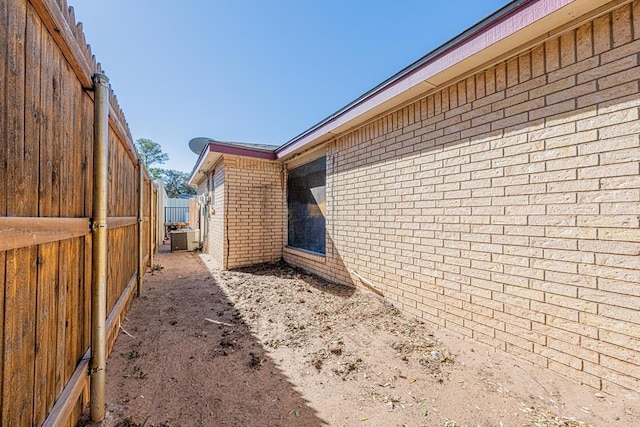 view of home's exterior with brick siding and central AC