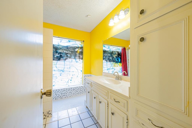 bathroom with tile patterned flooring, a textured ceiling, and vanity