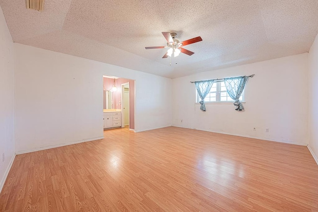 spare room with visible vents, a ceiling fan, a textured ceiling, light wood-type flooring, and baseboards