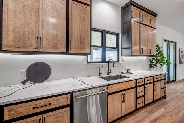 kitchen with sink, dishwasher, tasteful backsplash, wood-type flooring, and light stone countertops