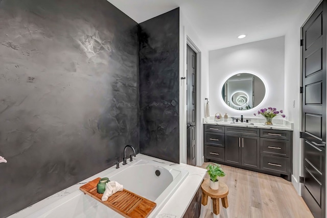 bathroom featuring wood-type flooring, vanity, and a bathtub