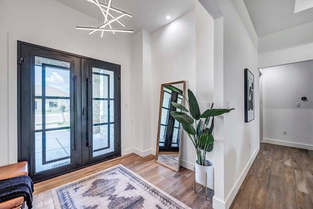 entryway featuring hardwood / wood-style floors, an inviting chandelier, and french doors