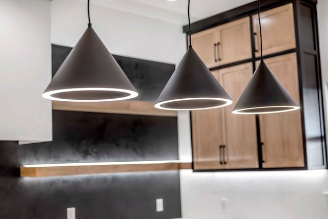 room details with hanging light fixtures and light brown cabinets