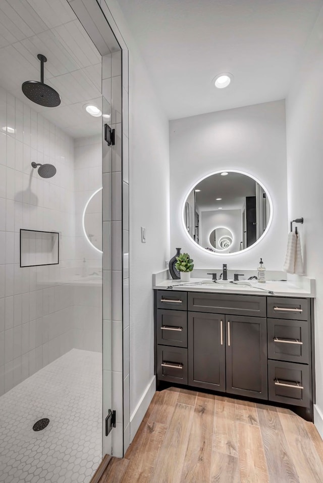 bathroom with hardwood / wood-style flooring, vanity, and walk in shower