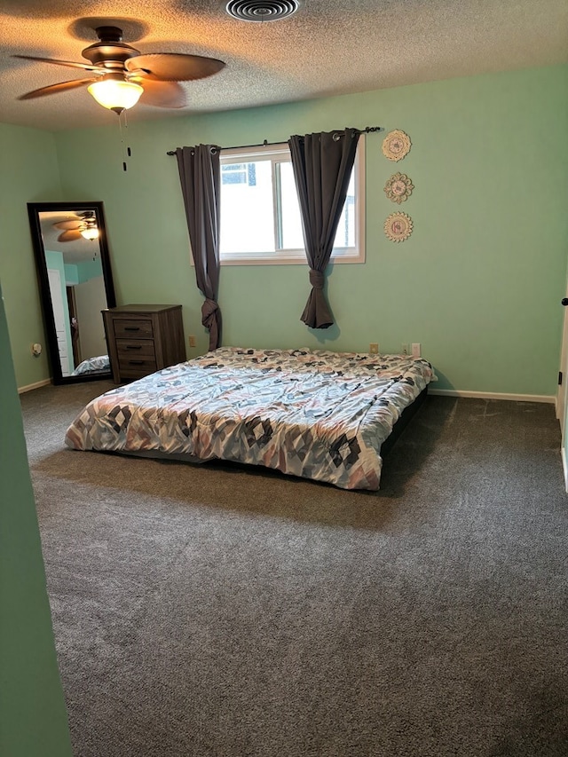 carpeted bedroom featuring ceiling fan and a textured ceiling