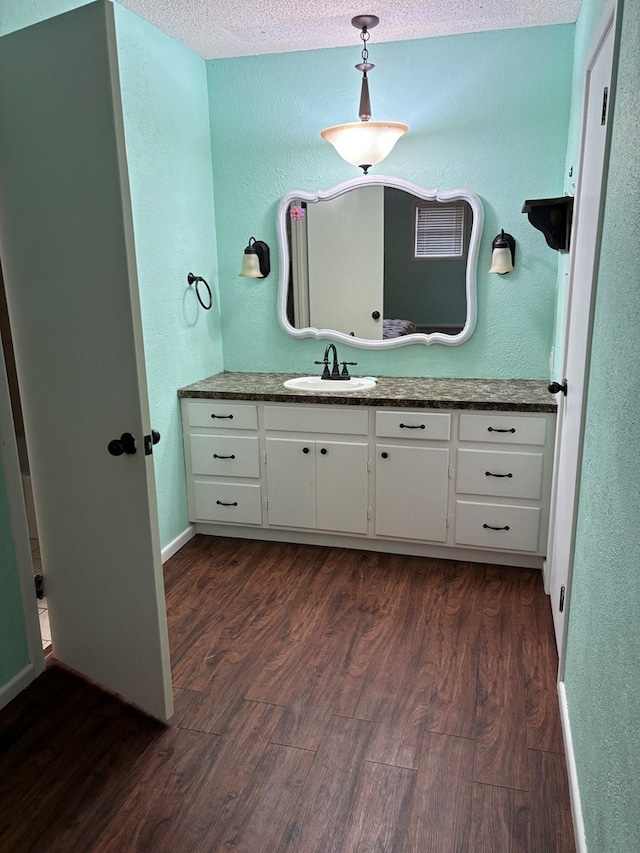 bathroom with vanity, wood-type flooring, and a textured ceiling