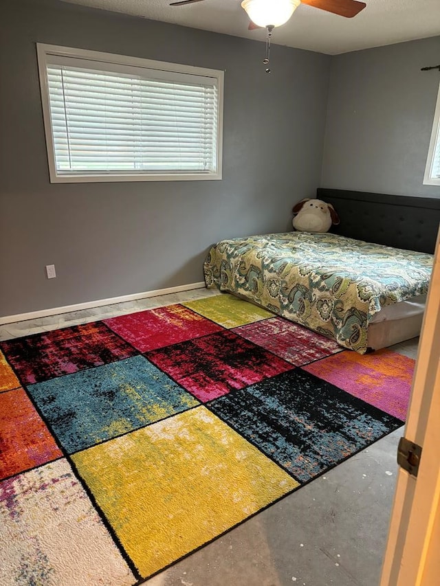 bedroom featuring ceiling fan and concrete flooring