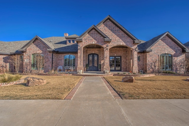 french country home featuring a front lawn and french doors