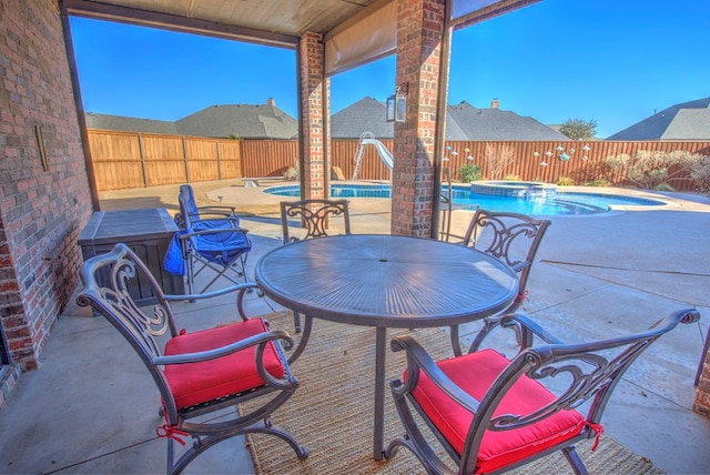 view of patio with a swimming pool with hot tub